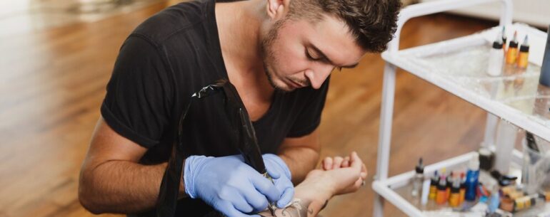 Mężczyzna robi tatuaż na delikatnej skórze klienta